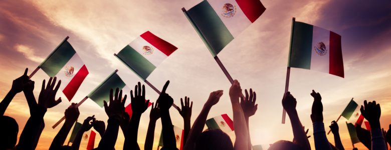 hands waving Mexican flags